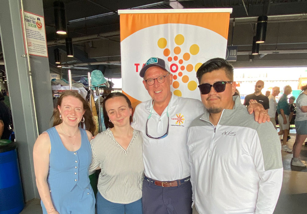 tango-nonprofit-reising-star-scholarship-winners-2025 TANGO founder Rollin Schuster with three of our Rising Star Nonprofit Scholarship winners on the field at the Hartford Yard Goats.